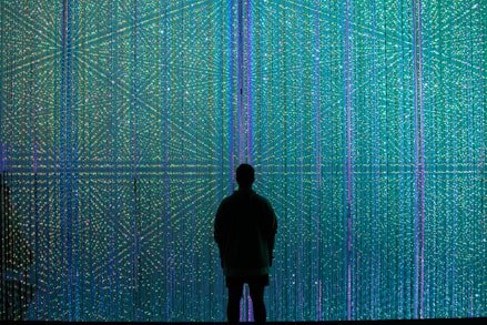 a person standing in front of a wall of lights