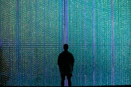 a person standing in front of a wall of lights