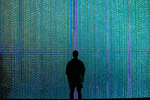 a person standing in front of a wall of lights