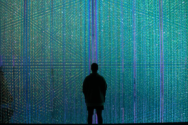 a person standing in front of a wall of lights