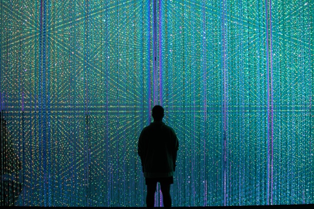 a person standing in front of a wall of lights