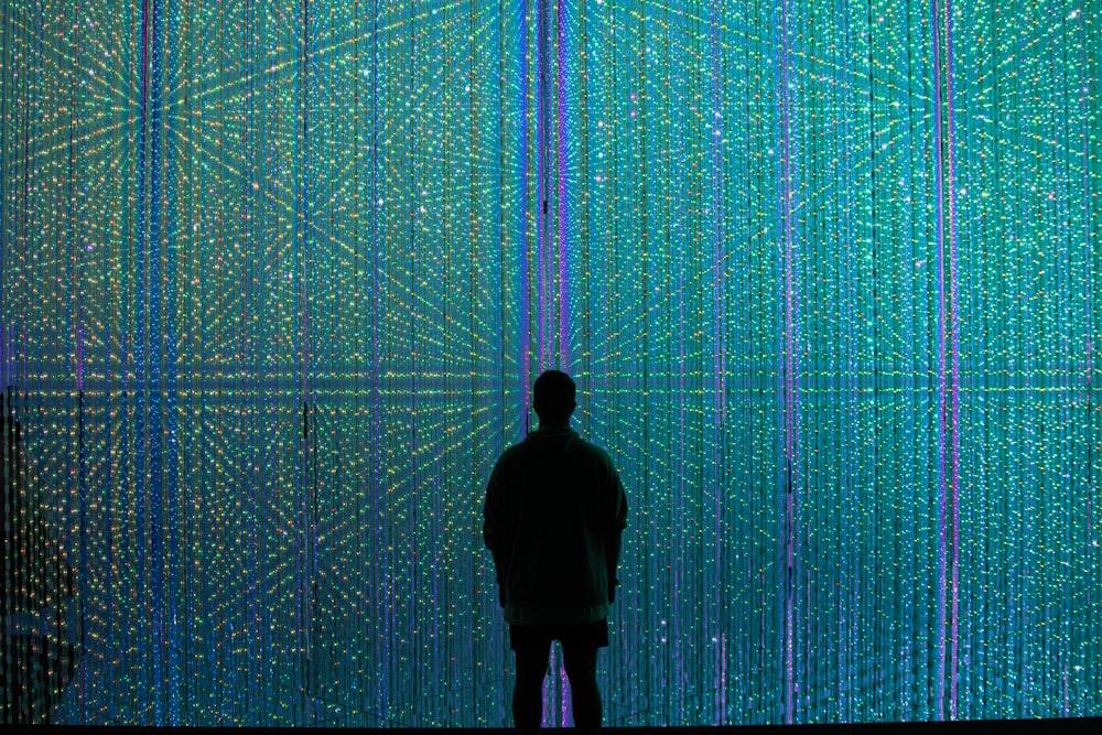 Una persona parada frente a una pared de luces