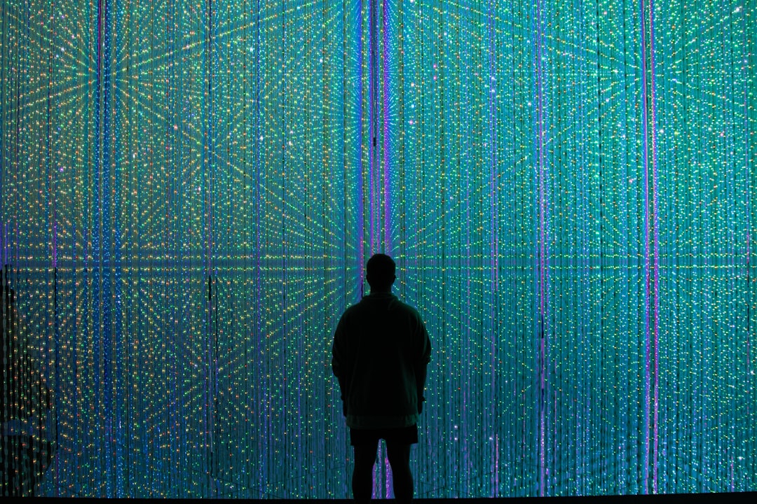 a person standing in front of a wall of lights,