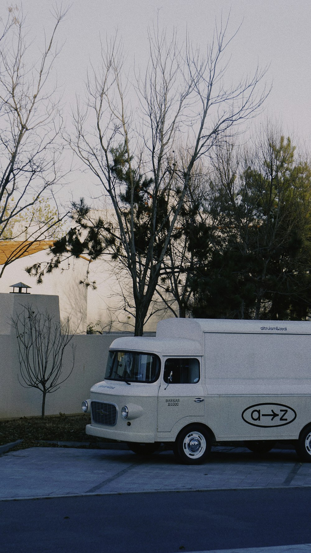 a white truck parked in front of a tree