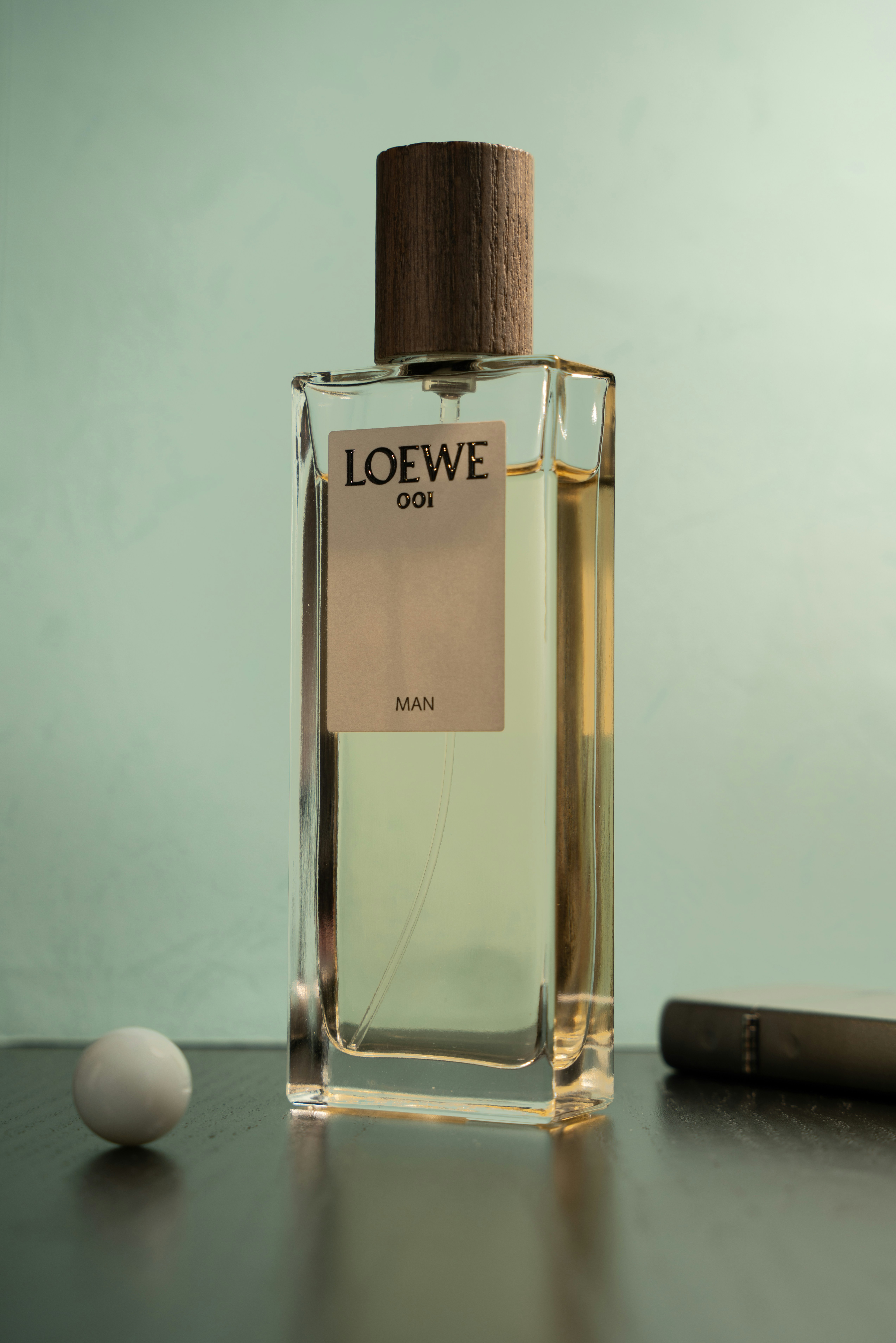 بطری عطر مردانه قهوه‌ای روی سطح چوبی با نور گرم