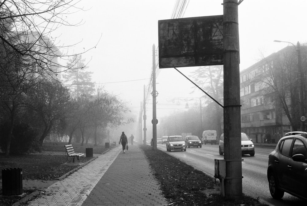 Una calle con coches y un cartel