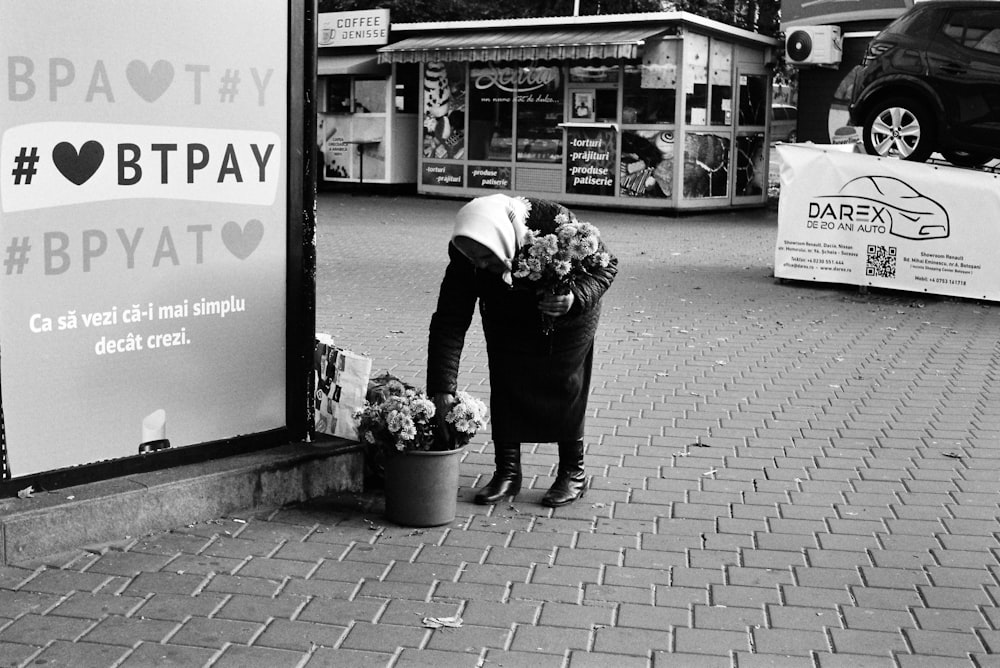a person bending over to pick flowers