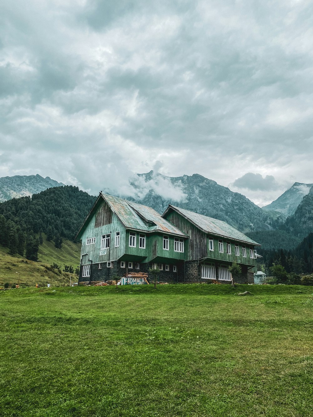 a green house on a hill