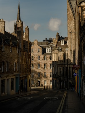 A quiet street in a historic Spanish town bathed in soft afternoon light.