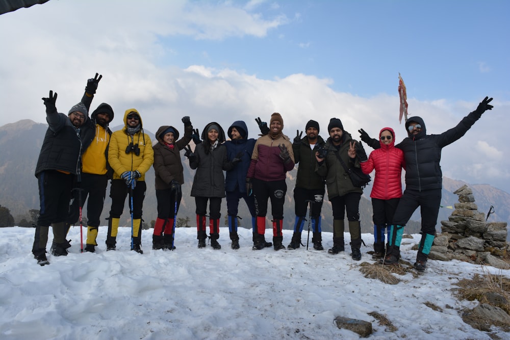 a group of people posing for a photo on a snowy mountain