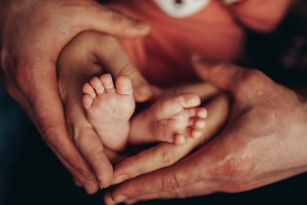 a close-up of hands holding a baby's feet