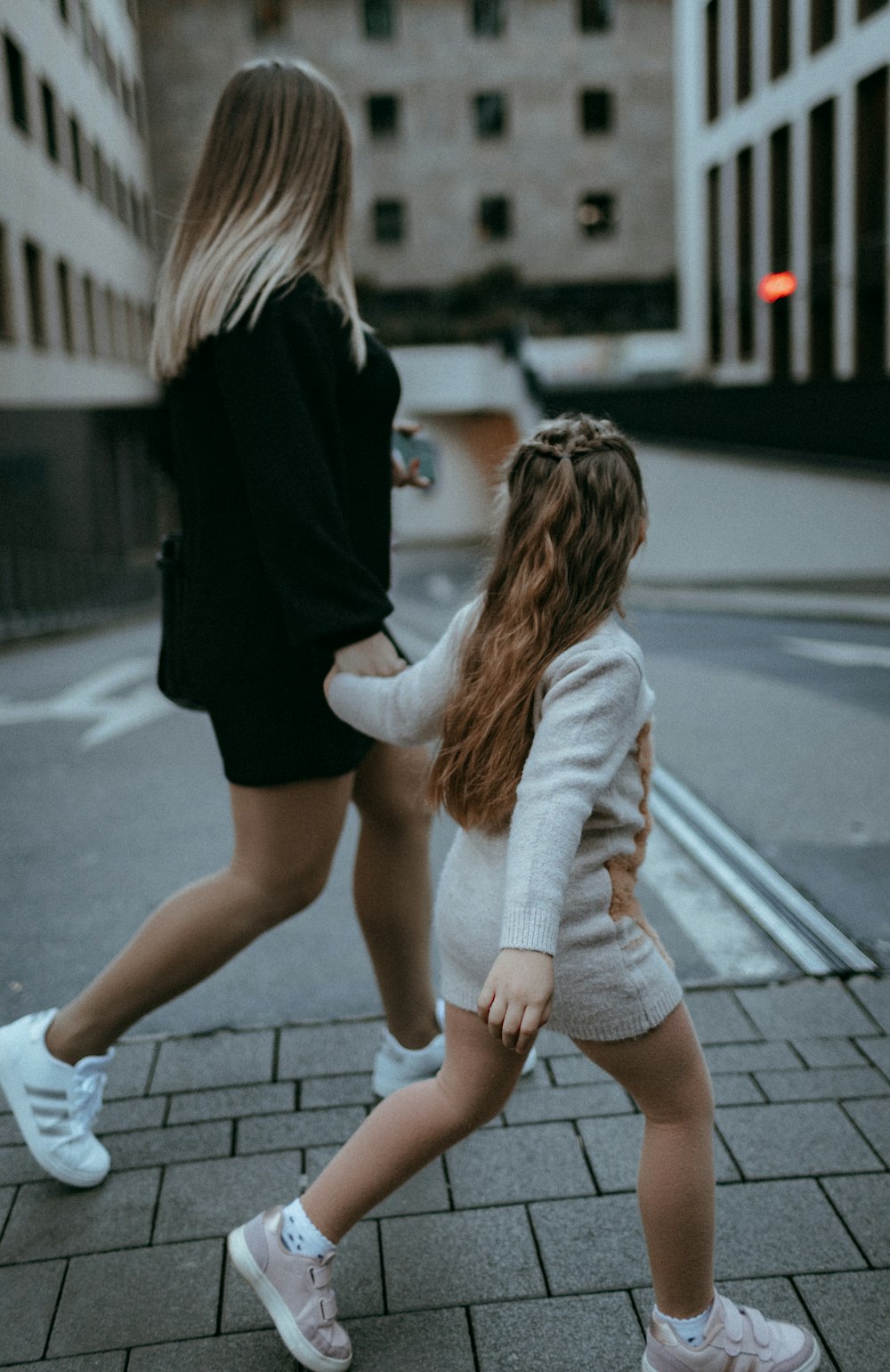 two women walking on a sidewalk
