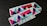 A stack of rectangular stickers featuring a geometric design with vibrant colors. The design includes overlapping triangles and other shapes with a glittery texture. The word 'DESIGN' is printed in a bold font at the bottom.