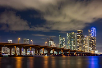 a bridge over water with a city in the background
