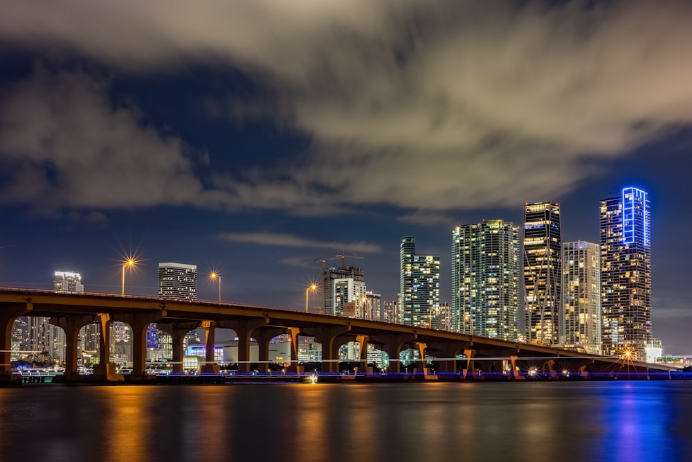 a bridge over water with a city in the background