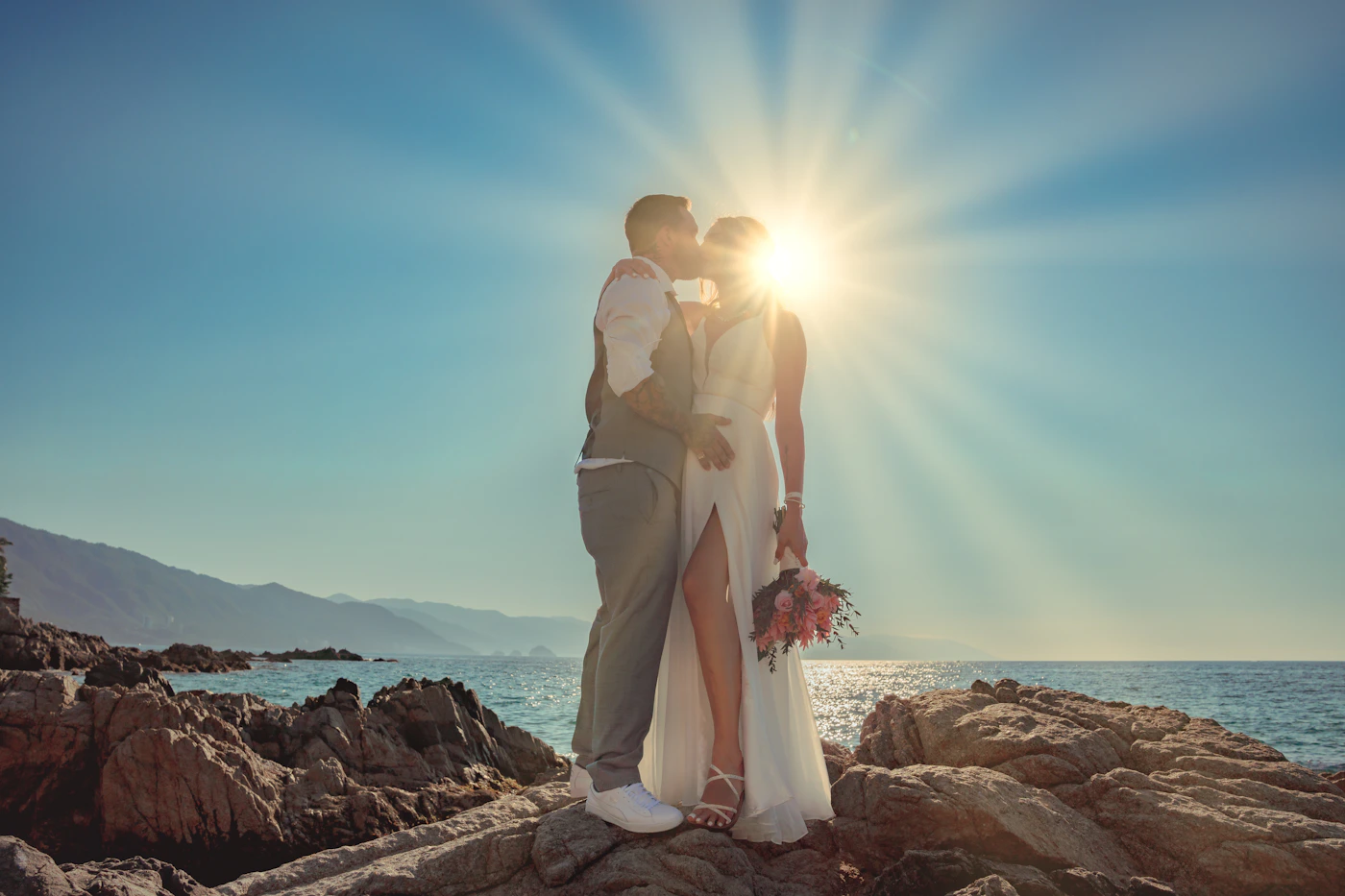 Couple in wedding attire during their Galápagos elopement with the green tropical vegetation and warm wet-season light behind them