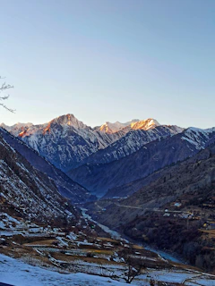 Sunrise over the snow-capped peaks of Himachal Pradesh with a river winding through the valley