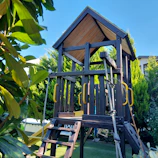 Outdoor toys set up in a sunny backyard with green grass