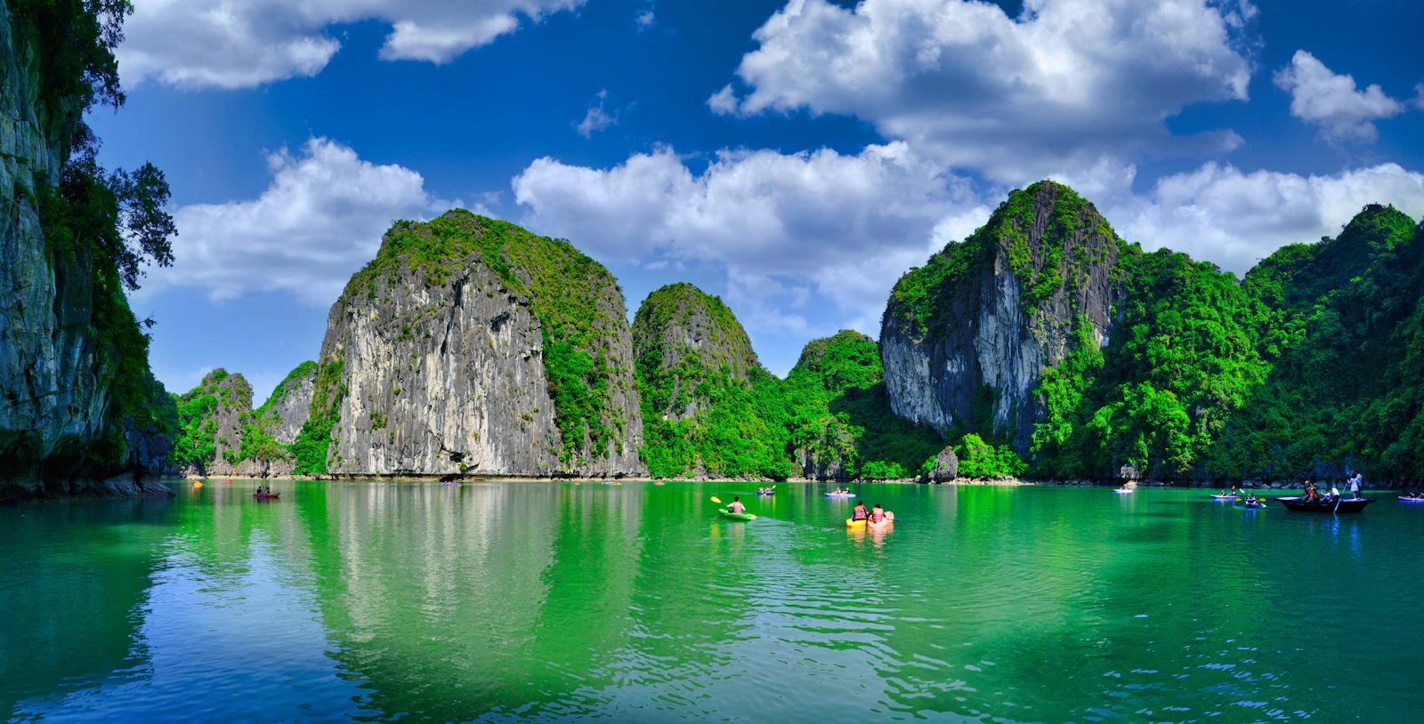 Emerald limestone karsts rising from the calm turquoise waters of Ha Long Bay at golden hour