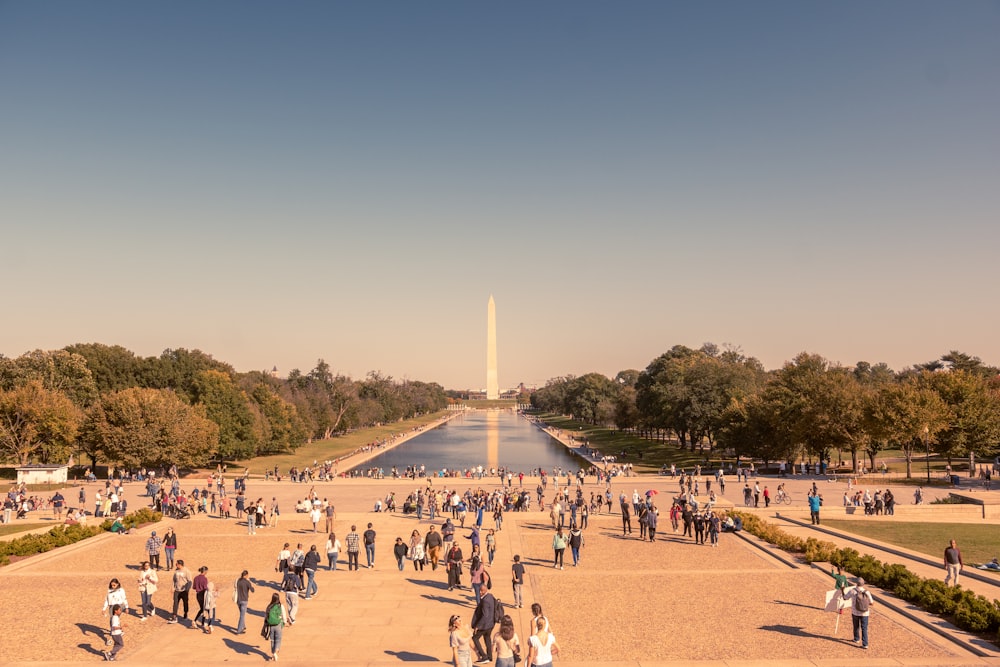 a large group of people walking around a monument with National Mall in the background