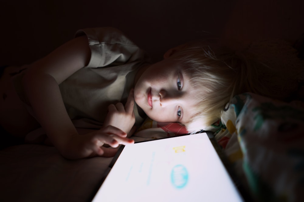 a person lying on a bed with a tablet