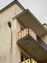 Close-up of a condo balcony corner showing water stains and peeling paint.