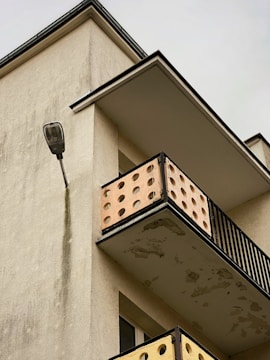 Close-up of a condo balcony corner showing water stains and peeling paint.