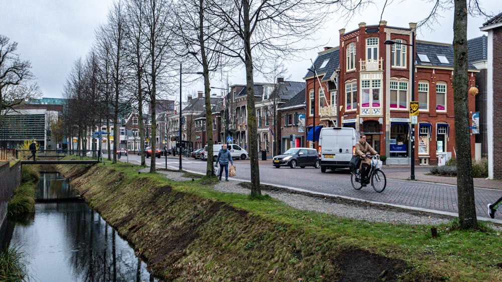 a person riding a bicycle on a road next to a river