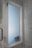 A frosted glass window set within a marble-tiled wall, featuring a chrome handle on the left. The surrounding walls have a polished marble finish with gray veining, adding to the modern aesthetic of the space.