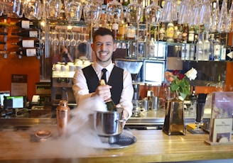 a person smiling and holding a silver teapot