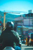 Rider cruising through urban streets on an oxide max scooter with skyscrapers in the background.