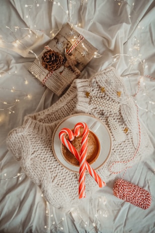 A cozy winter scene with a roaring fireplace, knitted throws, and twinkling Christmas lights.