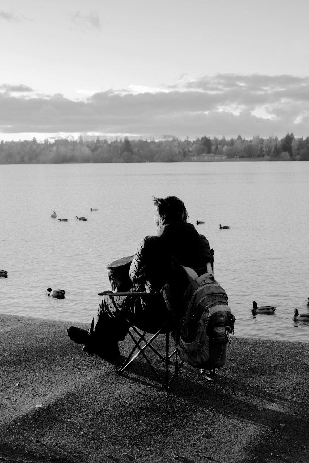 a person sitting on a chair looking at a body of water
