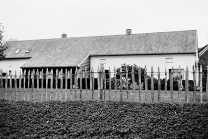 a fenced in yard with a house in the background