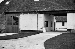 An old photograph of a countryside farmhouse blending past and present.