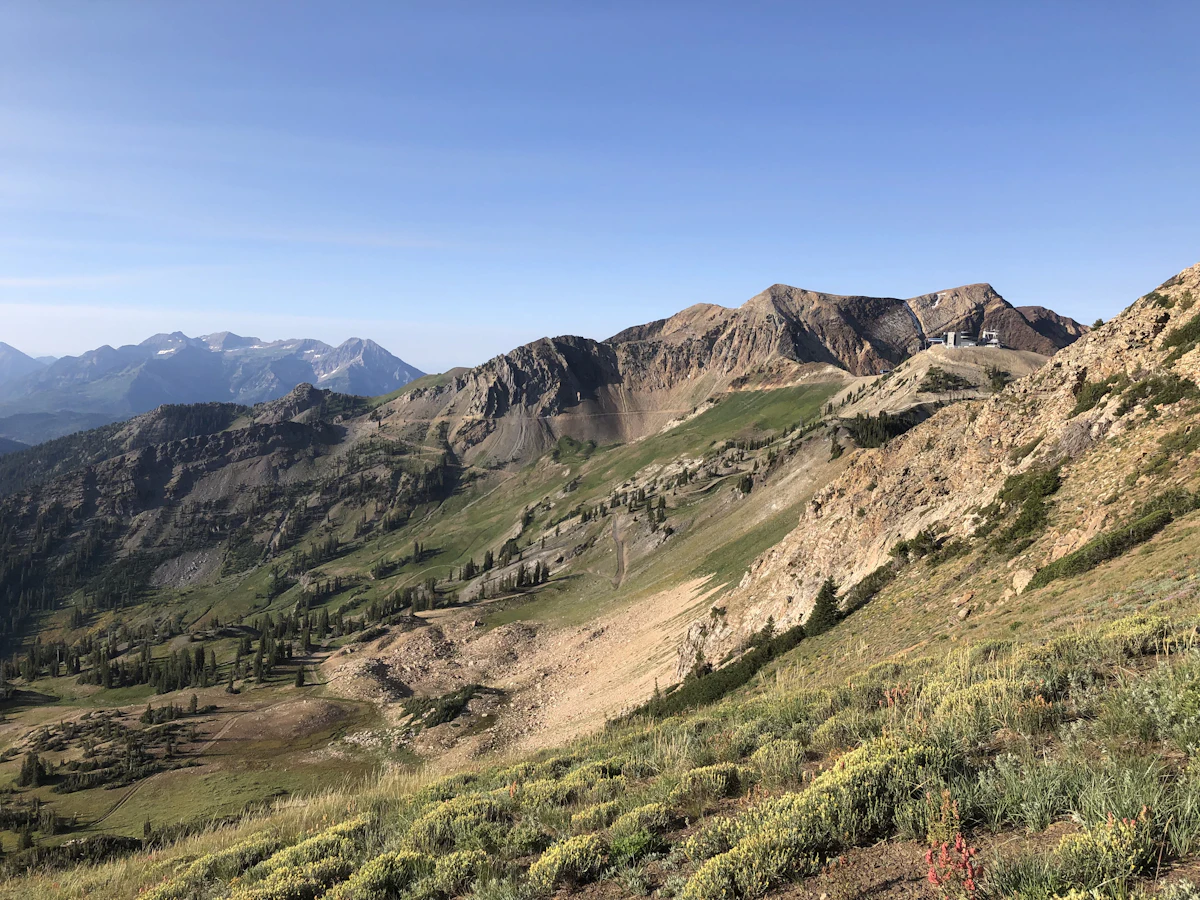 Mineral Basin in morning light, with rocky summits above green slopes and far ridges
