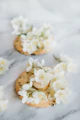 Close-up of beautifully decorated sugar cookies with delicate pastel icing and intricate floral patterns.
