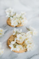 Close-up of delicately iced wedding sugar cookies with soft gold accents and blush florals.