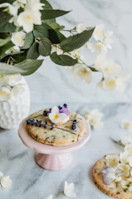 Close-up of elegantly iced wedding sugar cookies arranged with soft blush florals.