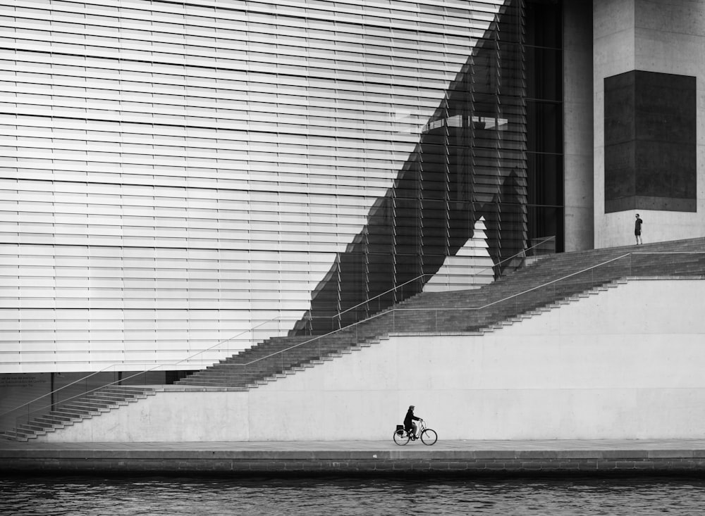 a person riding a bicycle on a concrete walkway