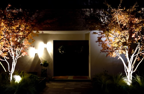 A cozy home entrance framed by warm autumn leaves and soft lighting.