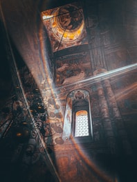Interior view of Nikolski Hram church during a morning liturgy with sunlight streaming through stained glass.