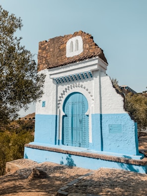 a small white building with a blue door and a blue door