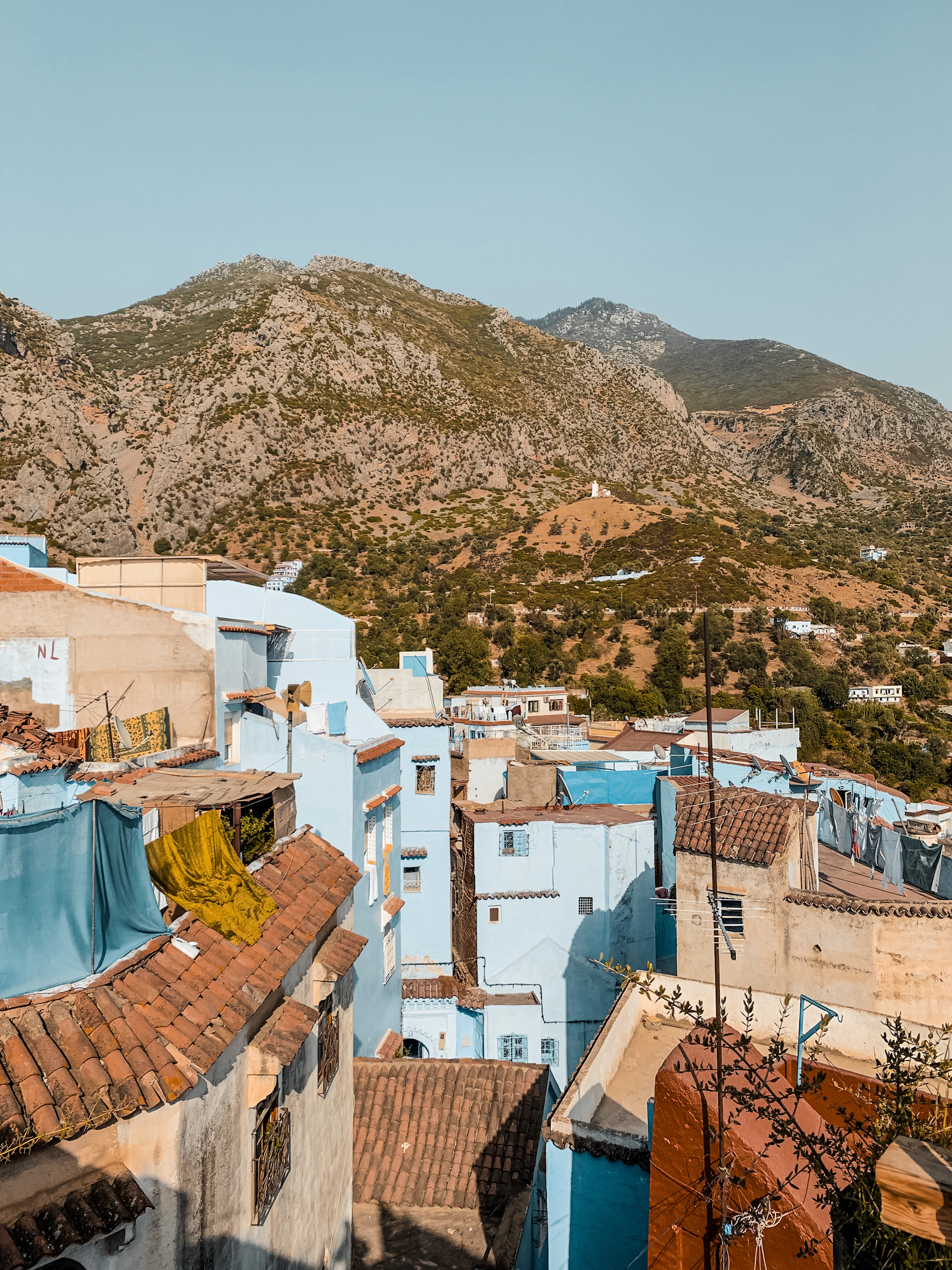 a group of buildings with mountains in the background