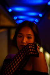 A sleek, dark-themed photo of a minimalist streetwear outfit illuminated by electric blue lighting.
