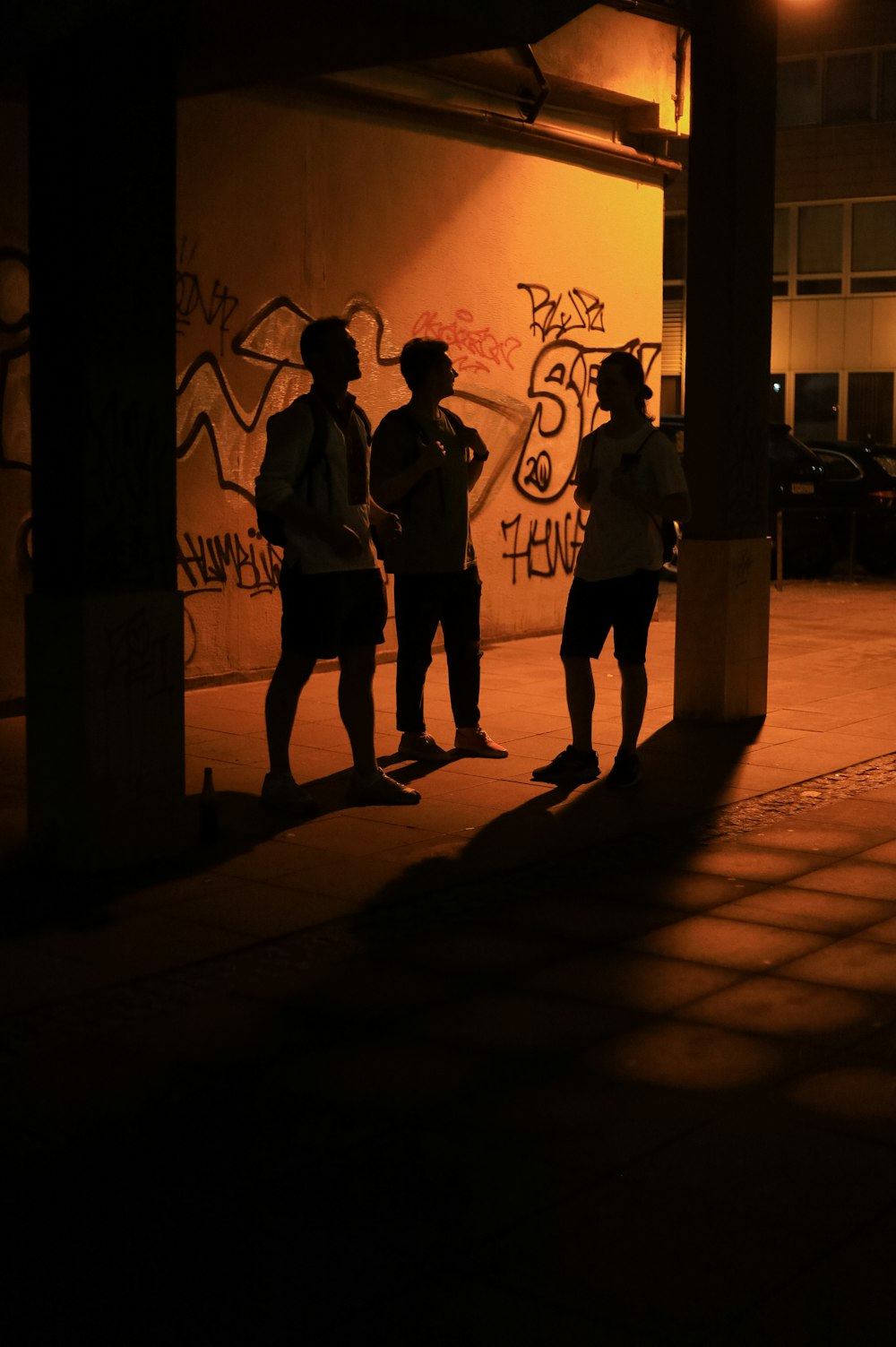 a group of people standing in front of a wall with graffiti