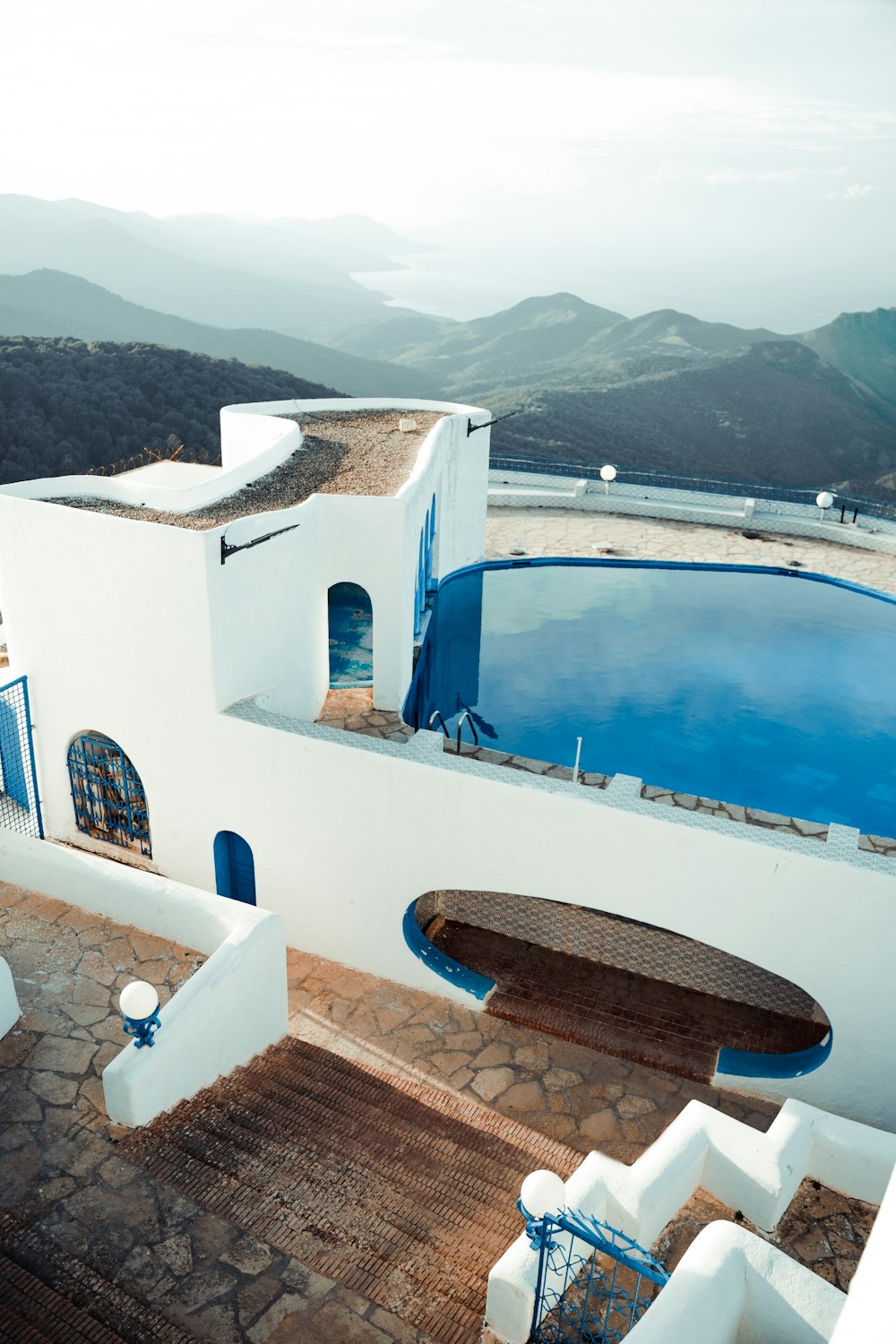 una piscina con terraza y sillas junto a ella