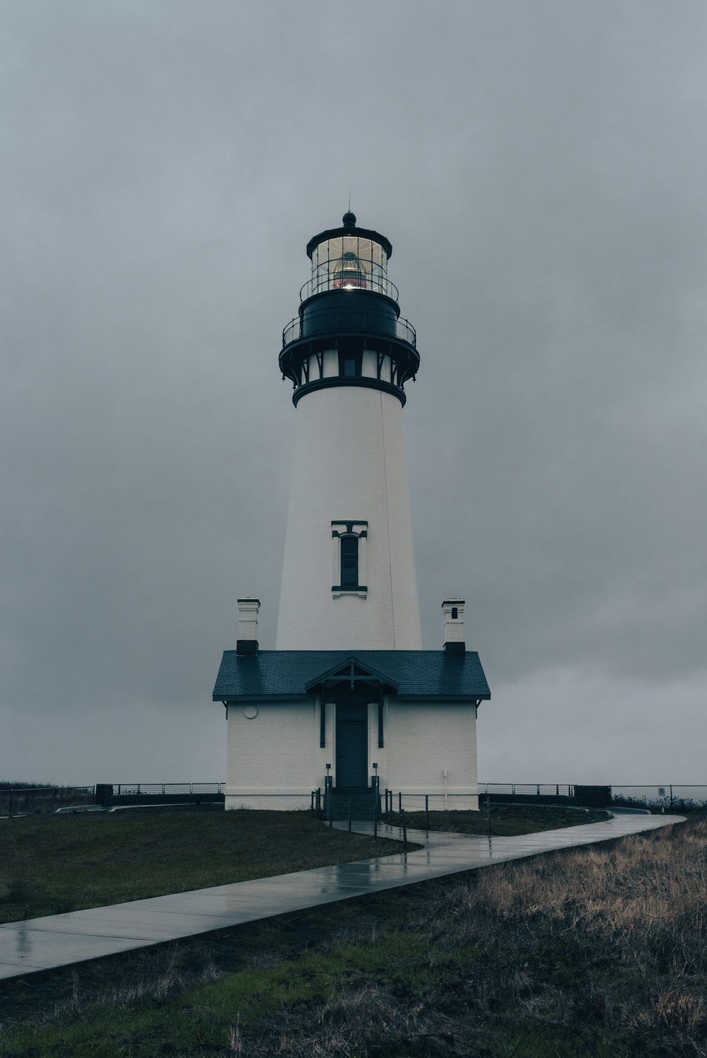 a lighthouse on a hill with Yaquina Head Light in the background