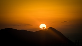 Sunset over the mountains surrounding Magé, casting warm golden light.