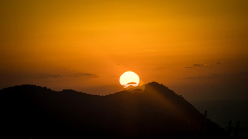 Sunset casting golden light over a rugged mountain ridge.